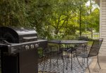 Patio table with dining space and a large gas grill in the back yard 